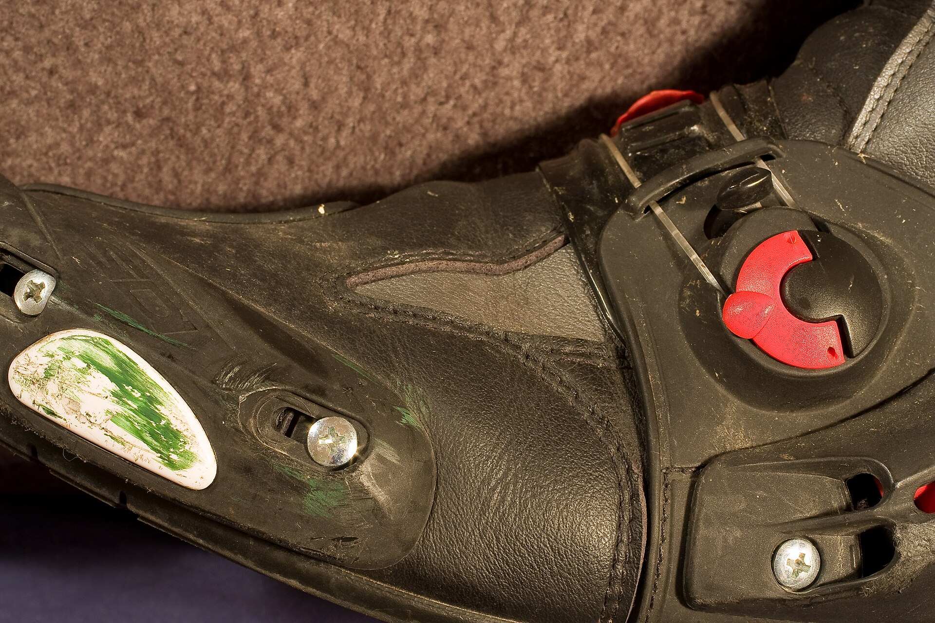 Replaceable toe slider and ankle protection on a race boot