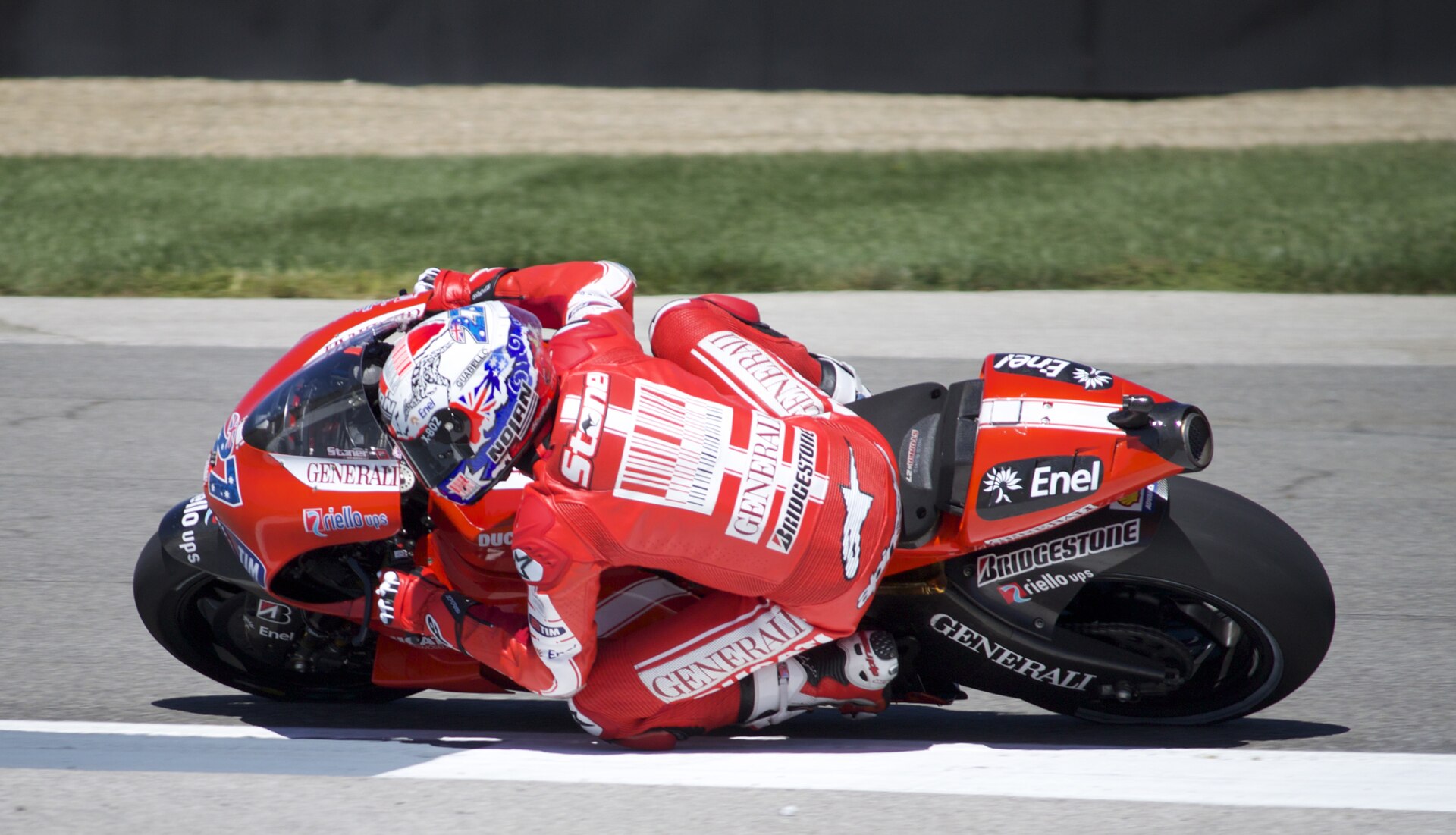 Motorcycle racer leaning through a corner with full protective equipment